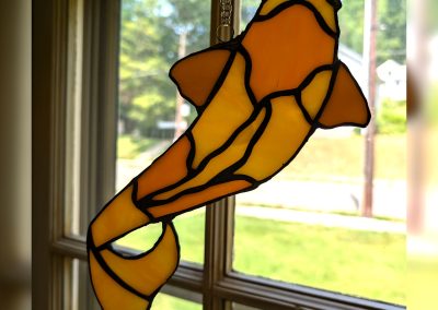 An image of a stained glass koi fish in yellow and orange | Copper & Light Studio