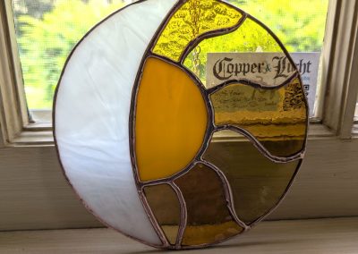 An image of a stained glass sun and moon in white yellow and orange | Copper & Light Studio